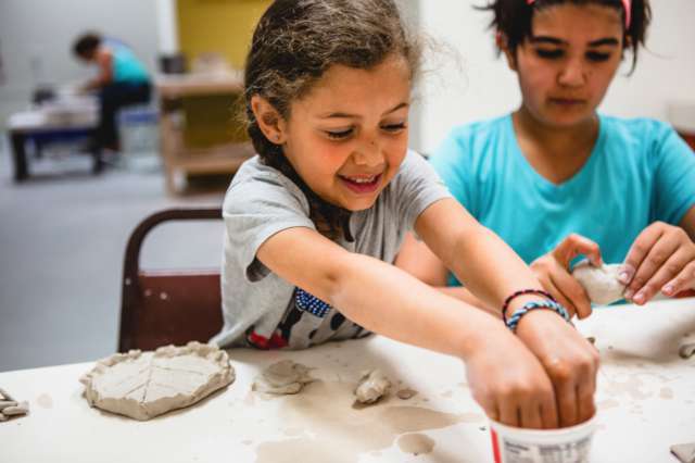 two young women working with clay