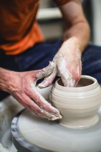 closeup of hands working on pottery wheel
